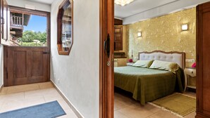 A bedroom with a bed, nightstand, and a view of the outside. - Apartment 'La Llosa' with Mountain Views, Private Terrace and Wi-Fi (Logrezana)