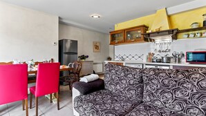 A modern kitchen with a dining area, a sofa, and a TV. - Apartment 'La Llosa' with Mountain Views, Private Terrace and Wi-Fi (Logrezana)