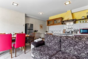 Una cocina moderna con comedor, sofá y televisor.