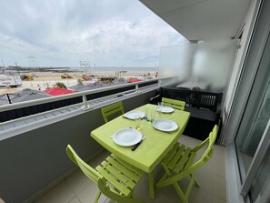 A balcony with a table set for two, overlooking a construction site with vehicles and equipment.