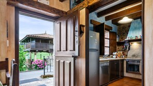 Une cuisine équipée d’un réfrigérateur, d’un four et de meubles de rangement en bois.