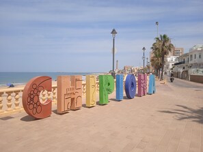 A paved walkway with colorful, uniquely shaped structures along the seaside. - Apartment 'Chipiona Centro y Playa' with Private Terrace, Balcony and Wi-Fi (Chipiona)