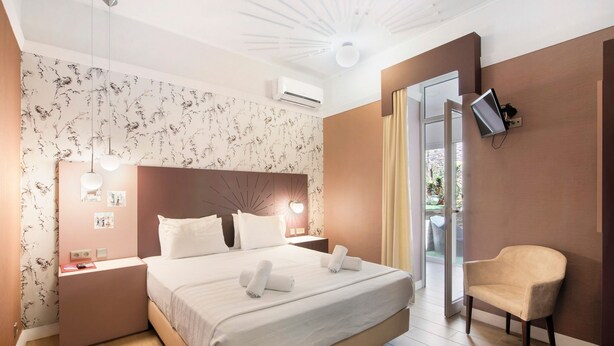 Une chambre d’hôtel équipée d’un lit, de tables de chevet, d’une chaise, d’un téléviseur et offrant une vue sur l’extérieur.