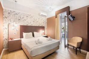 A hotel room with a bed, bedside tables, a chair, a TV, and a view of the outdoors. - Room 'Quarto Casal Comfort Plus 106' with Private Terrace, Wi-Fi and Air Conditioning (Faro)