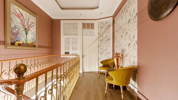 A hallway with a staircase, a door, and two yellow chairs. - Room 'Quarto Casal Comfort Plus 104' with Shared Terrace, Wi-Fi and Air Conditioning (Faro)