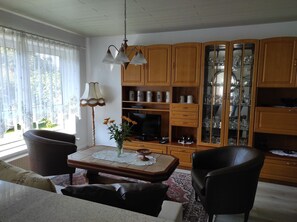Una sala de estar con un mueble de madera, un televisor y una mesa de centro.
