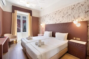 A hotel room with two beds, a desk, a chair, a nightstand, and a decorative wall. - Room 'Quarto Twin Comfort Plus 102' with Shared Terrace, Wi-Fi and Air Conditioning (Faro)