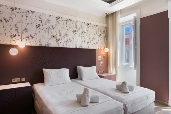 A hotel room with two beds, a floral wallpaper, a large window, and a sunburst headboard. - Room 'Quarto Twin Comfort Plus 101' with Shared Terrace, Wi-Fi and Air Conditioning (Faro)