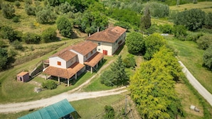 A rural house with a red-tiled roof, surrounded by greenery and a dirt path. - Holiday Home 'Poggio1' with Shared Pool, Shared Garden and Wi-Fi (Fauglia)