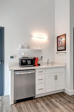 A compact kitchen with a built-in microwave, coffee maker, and dishwasher.