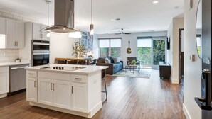 Una cocina moderna con armarios blancos, una isla central y un comedor.