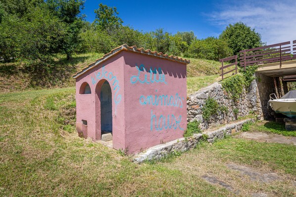 A pink building labeled 'Little animal house' with arched windows and a stone wall.