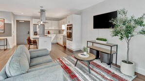 Un appartement moderne comprenant un salon, une cuisine et un coin repas.