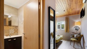 A room with a wooden ceiling, a bed, a chair, a bedside table, and a mirror. - Apartment 'Quarto Twin 203' with Shared Terrace, Wi-Fi and Air Conditioning (Faro)
