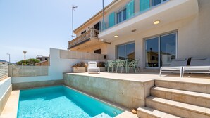 Une piscine avec des marches menant à un patio couvert.