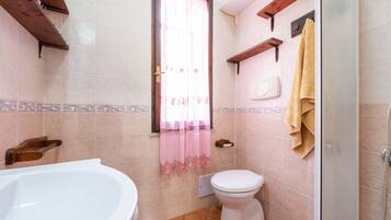 Une salle de bain avec une baignoire, des toilettes et une douche.