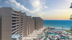 A high-rise hotel with multiple balconies overlooking a beach and a pool area with various water features. - Las Palomas Phase I Rubi 901 Exceptional OceanView 3BR 3BA Unit (Puerto Peñasco)