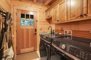 A compact kitchen with wooden cabinets, a washing machine, and a window with frosted glass.