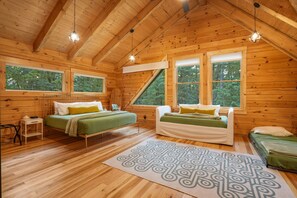 A cabin with two beds, a small table, and a large window.