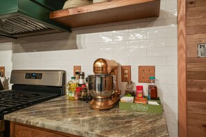 A kitchen with a stand mixer, a coffee machine, and various kitchen appliances. - The Leaflet | Hocking Hills, Swim Spa, Theater (Laurelville)