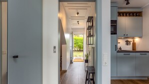 Eine moderne Küche mit grauen Schränken, einer Holz Arbeitsplatte und Blick in den angrenzenden Essbereich.