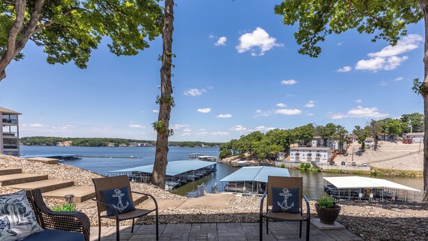 A patio with two wicker chairs, one with a cushion featuring an anchor design.