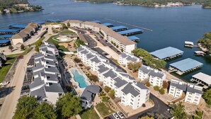 A hotel with multiple buildings, a swimming pool, and docks along a lake.