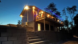 A two-story building with a wooden exterior and a balcony. - Gorgeous New Cabin with 70Acres!Trails, Waterfalls and Amazing Rock Formations! (Cub Run)