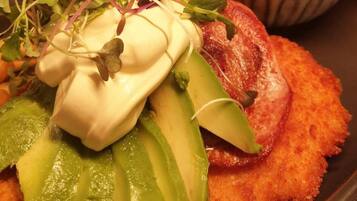 A dish called Elephant Schnitzel with avocado slices, sprouts, and a dollop of sauce.