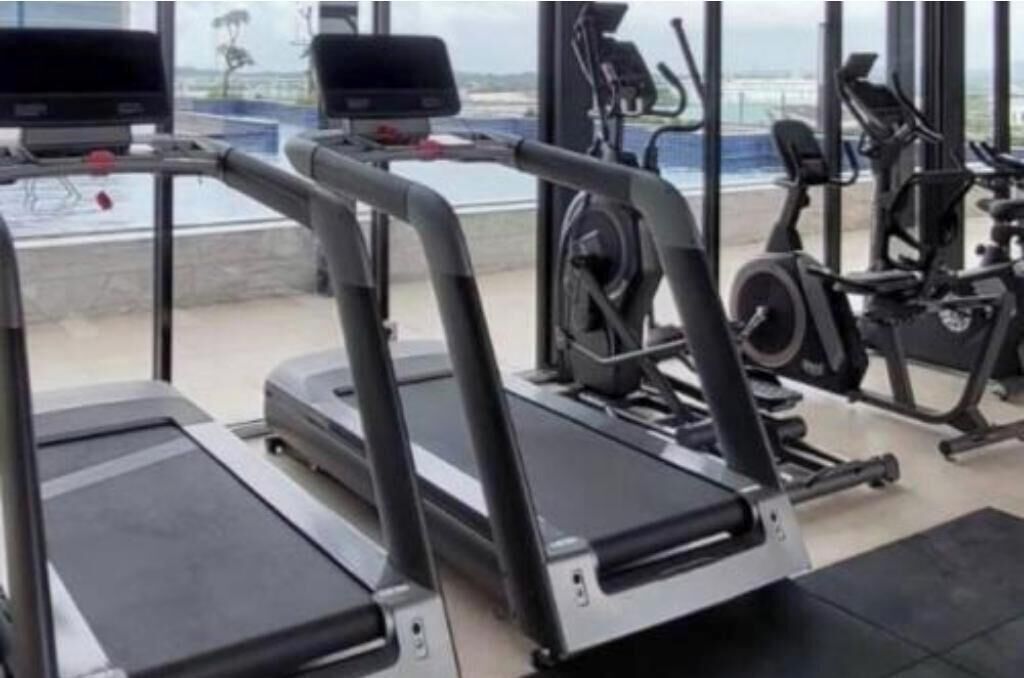 A gym with treadmills, stationary bikes, and weight machines.