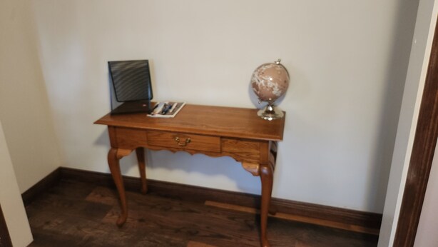 A wooden desk with a laptop and a globe. - Relaxing, Peaceful 1-bedroom Pet- Friendly Apartment  (Mason City)