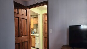 A hallway with wooden doors leading to a kitchen area. - Relaxing, Peaceful 1-bedroom Pet- Friendly Apartment  (Mason City)