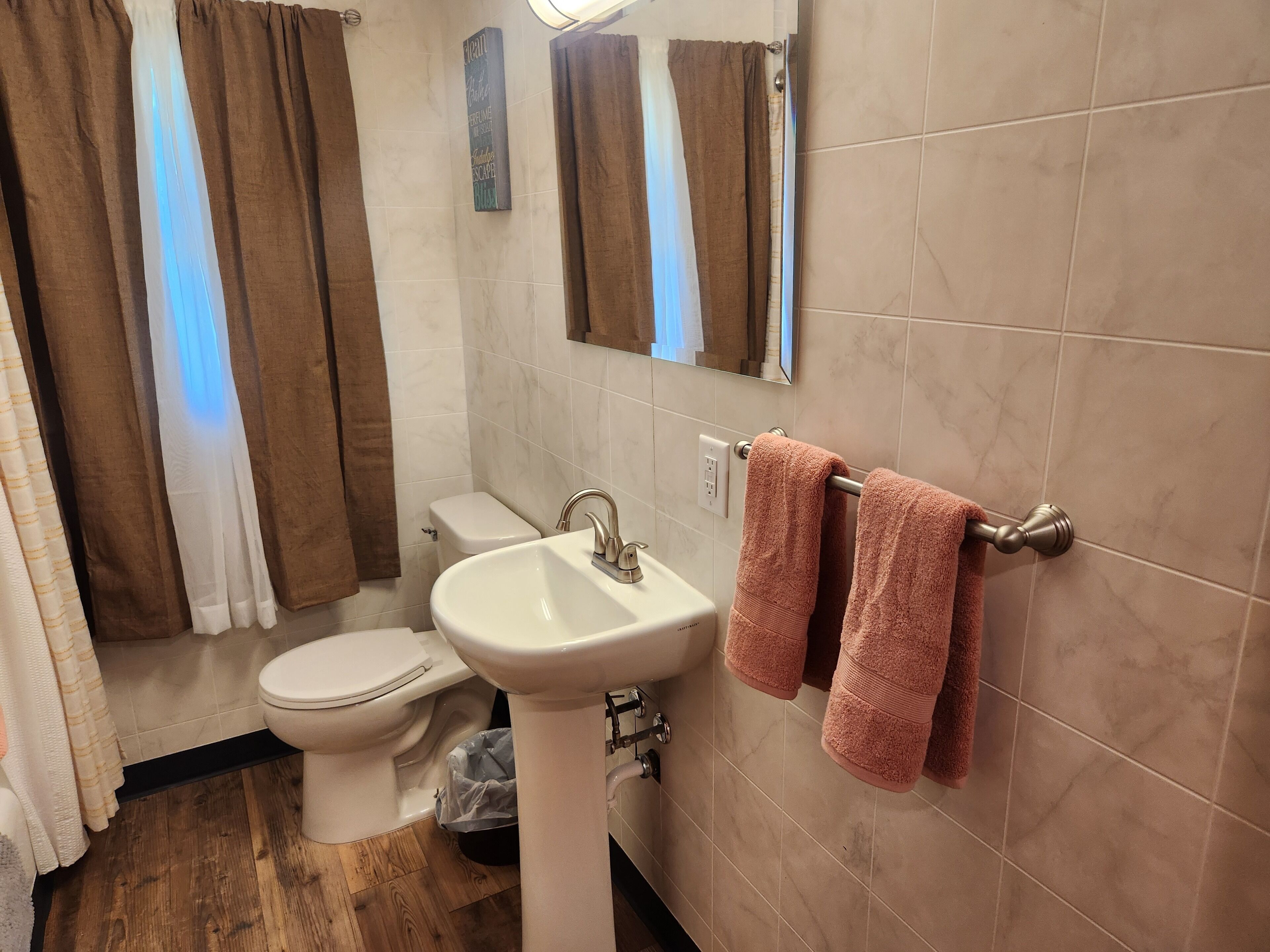 Une salle de bain équipée de toilettes, d’un lavabo et d’un porte-serviettes.