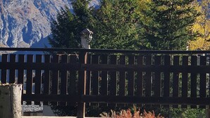 A view of snow-capped mountains, a wooden fence, and a building with a sloped roof. - Apartment 'Piccolo Paradiso' with Mountain View, Private Garden and Wi-Fi (Gimillan)