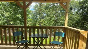 A wooden deck with a table and two chairs. - Texas Longhorn Ranch-Private Cabin-Pasture Views (Licking)