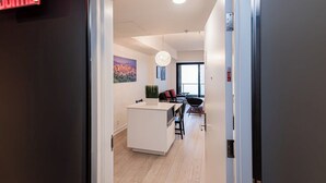 A modern interior with a white kitchen island, a dining area with a black chair, and a large window.