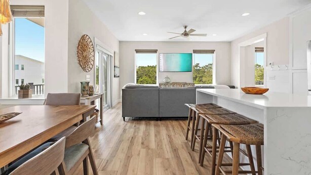 A modern kitchen with a dining area, a large window, and a ceiling fan. - Family-Friendly Home with Rooftop Lounge (Inlet Beach)