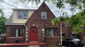 A two-story brick house with a red front door, numbered 520, and a black car parked in the driveway. - Charming 4-bedroom house with WiFi and AC in beautiful Niagara Falls (Niagara Falls)