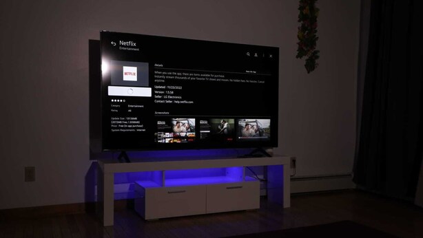 A television displaying the Netflix app interface with a dark room background. - Charming 4-bedroom house with WiFi and AC in beautiful Niagara Falls (Niagara Falls)