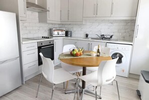 Enjoy meals around the central table in this well-equipped kitchen with oven, microwave, and washing machine.