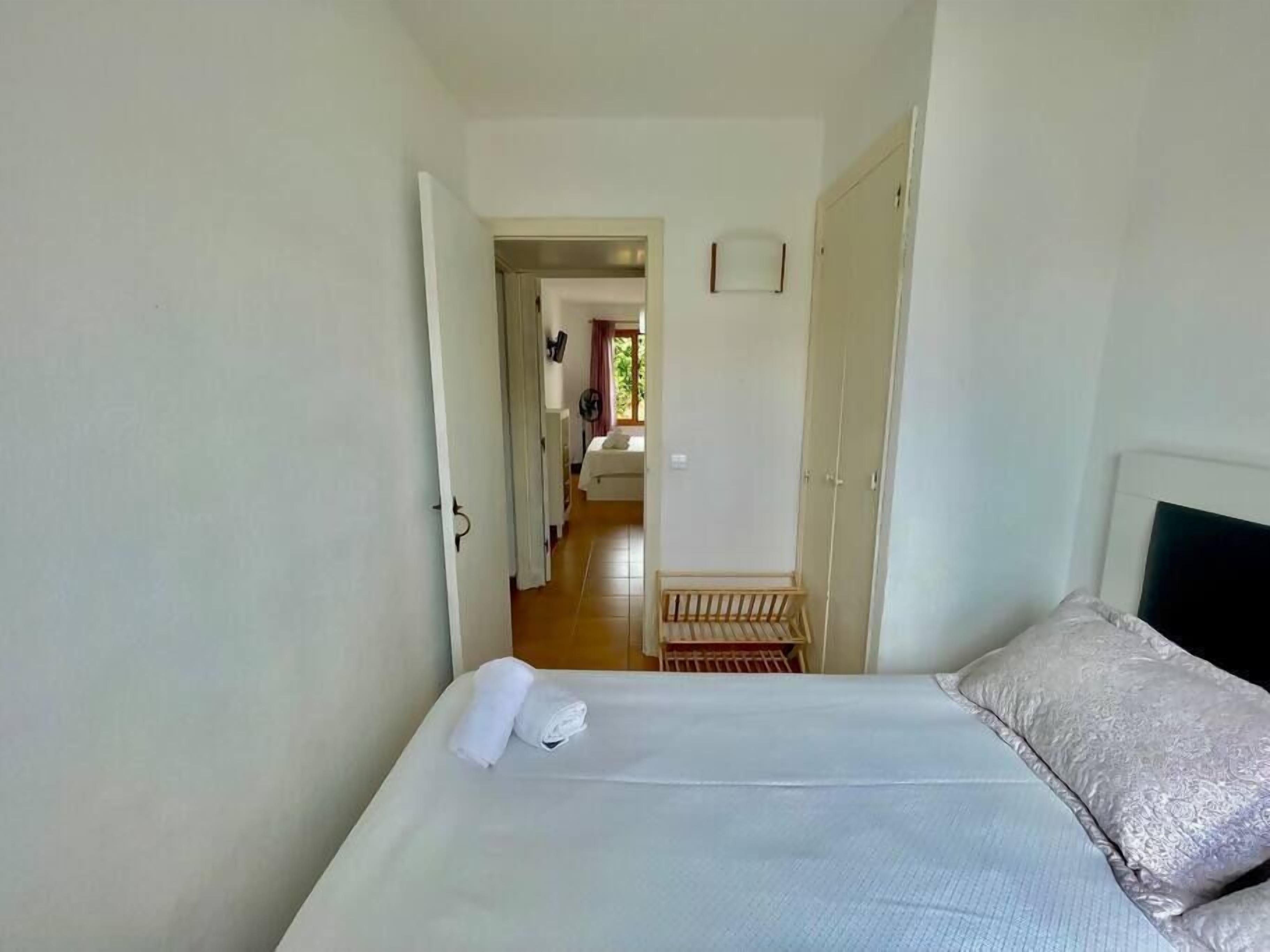 Una habitación de hotel con cama, armario y vista a la habitación contigua.