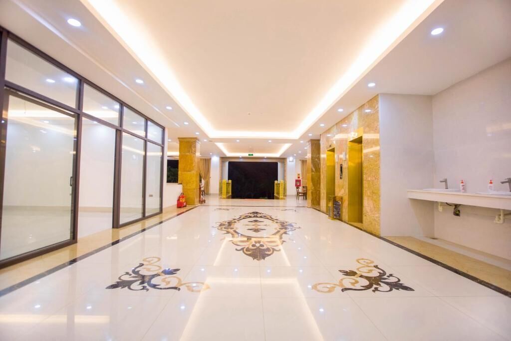 Egy hotel folyosója, ahol a padló fényesre polírozva, az ajtók üvegből készültek, és található itt egy recepciós pult is.