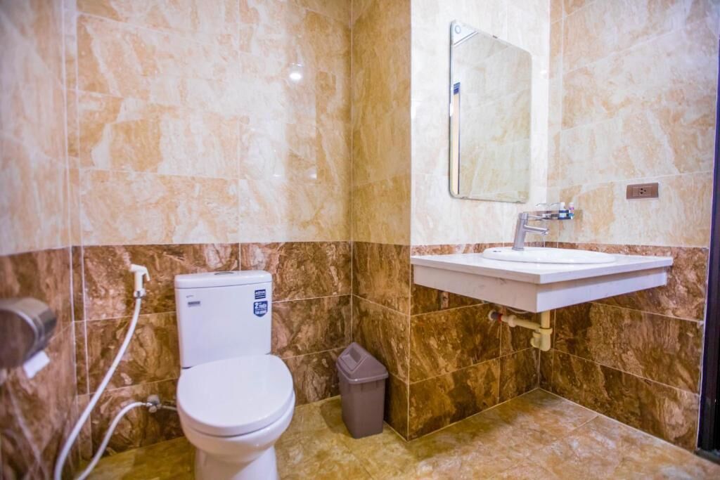 Un bagno con il water, un lavandino e uno specchio.