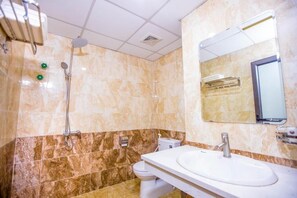 A bathroom with a white sink, a mirror, a shower, and a toilet. - Tu Phuong Hotel TH by Bay Luxury (Hoang Thanh)