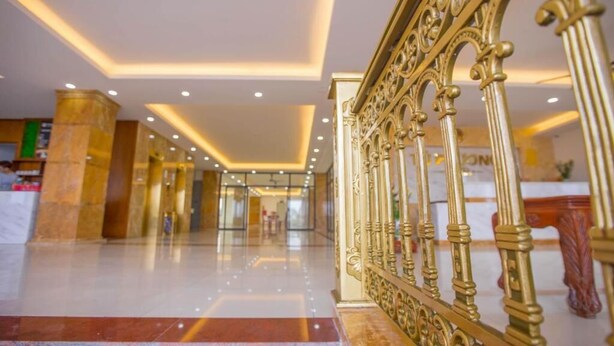 A hotel lobby with a marble floor, golden railings, and a modern ceiling design. - Tu Phuong Hotel TH by Bay Luxury (Hoang Thanh)