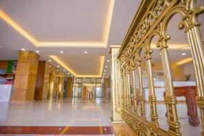 A hotel lobby with a marble floor, golden railings, and a modern ceiling design. - Tu Phuong Hotel TH by Bay Luxury (Hoang Thanh)