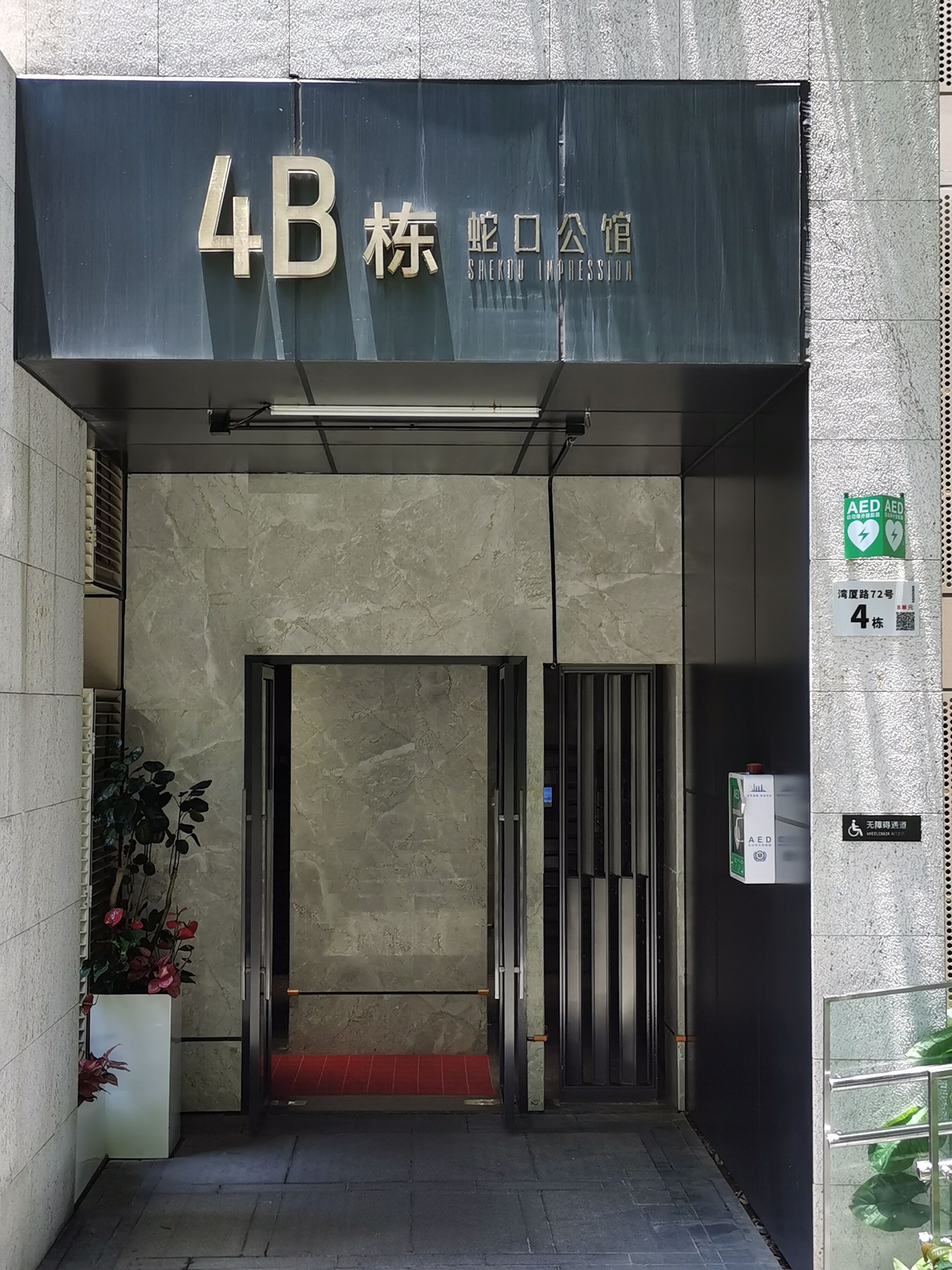 Entrada de un edificio con un letrero que dice "4B 株" y "Sakai Impression".