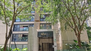 Un edificio moderno con un letrero que dice "4B" y una entrada con portón.