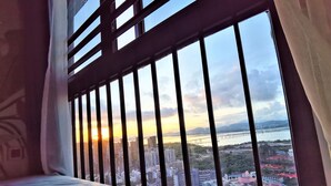 Una habitación con un ventanal grande que ofrece vistas a un paisaje urbano, incluyendo un puente y edificios.