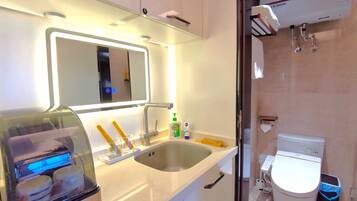 A modern bathroom with a sink, mirror, and a toilet.